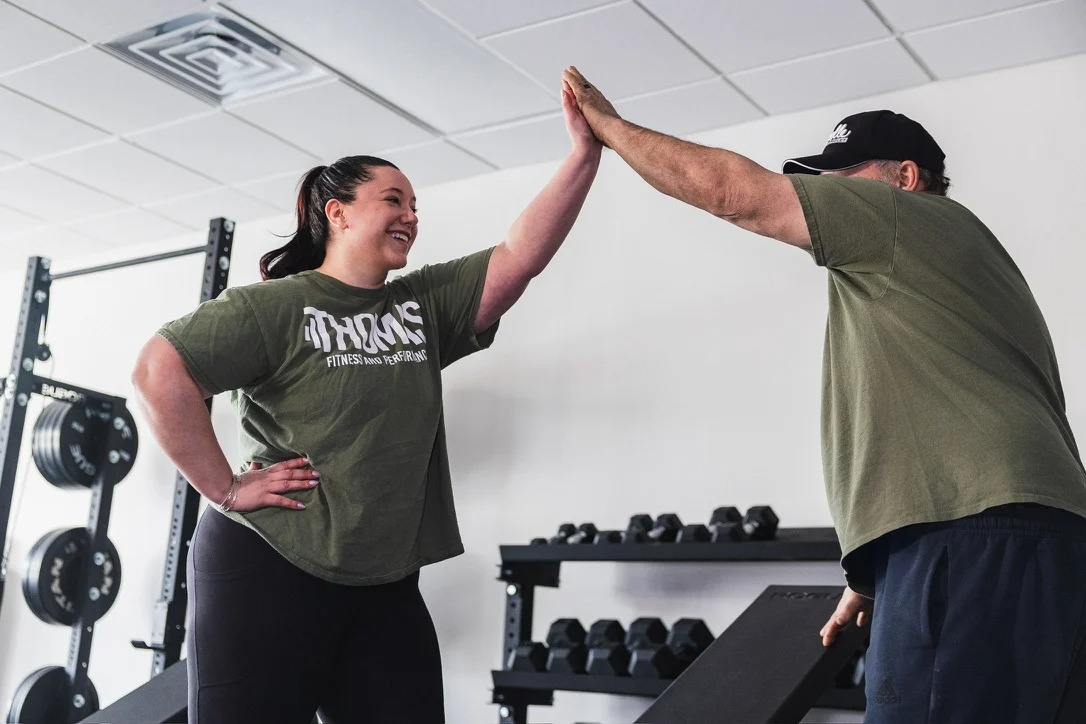 Coach high-fiving a client at the Farmington, CT gym